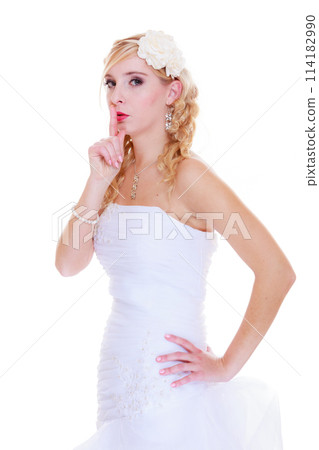 Bride in white wedding dress showing silence sign 114182990