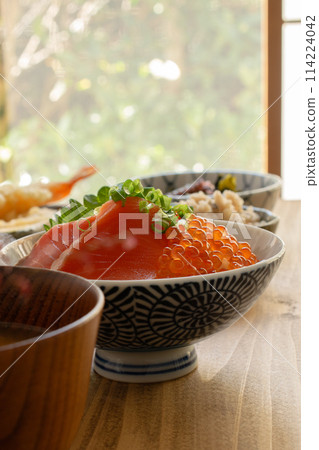 Oyakodon with salmon and salmon roe served on a wooden table 114224042