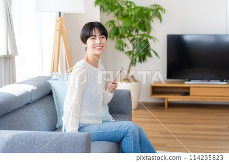 A woman who operates a smartphone in the room 114235823