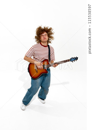 Musical Passion. Young curly-haired artist passionately playing guitar, making solo performance isolated on white background 115538597