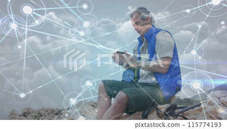 Caucasian senior man sitting on hillside taking photo with smartphone, over network of connections 115774193