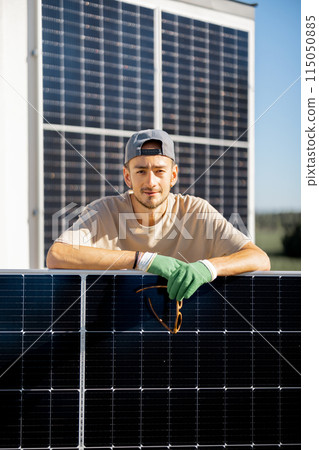 Portrait of a man standing with solar panel 115050885