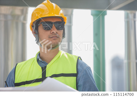 Male operator worker reading blueprint checking drawing plan cooling air piping HVAC system 115114700