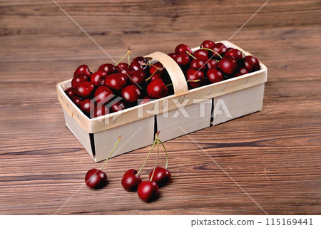 Ripe natural cherries, sweet cherries in a birch bark basket on a wooden background, close-up 115169441