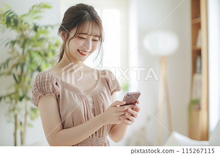 Young woman using a smartphone in the living room 115267115