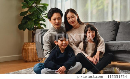 Smiling family relaxing in the living room 115351734