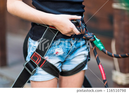 Girl wearing safety harness in rope park 116510798