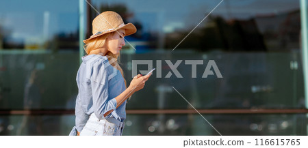 Female traveler with baggage using GPS to find destination or hotel on vacation, navigating with mobile phone map app 116615765