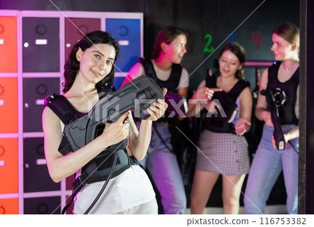 Cheerful and happy girl pose in locker room before laser tag match. 116753382