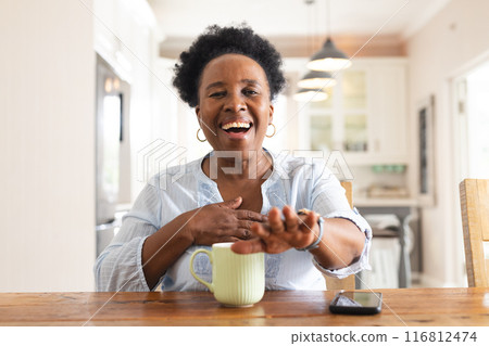 Portrait of happy senior african american woman having video call at home 116812474