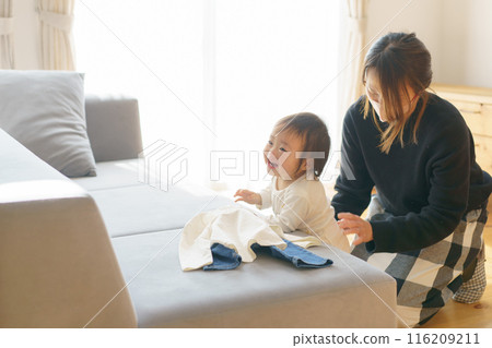 Mom changing her child's clothes 116209211