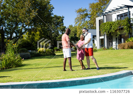 Outdoors, diverse senior friends laughing near pool 116307726