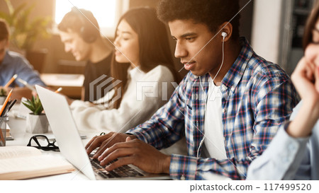 Student learning lessons in school library, making research on laptop and browse internet 117499520