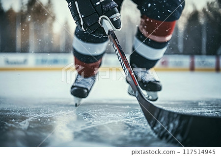 Hockey player skating and controlling the puck on the ice rink during match 117514945