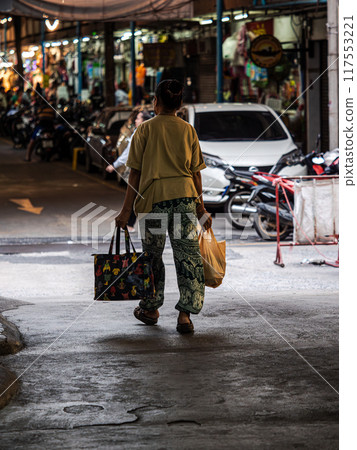 Woman Walking With Bags in a Bangkok Alleyway 117553221