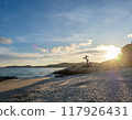 Mermaid sculpture in outdoor public sand and rock beach with seascape view at Samet island, Rayong, Thailand, under twilight sunset cloudy sky 117926431