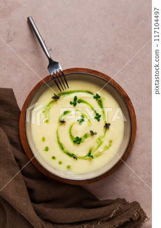 Mashed potatoes, with green butter and micro greenery, homemade, on a beige table, no people, top view, 117104497