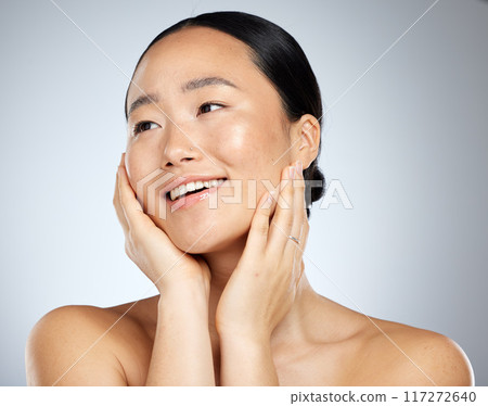 Asian woman, face glow and skincare routine with hands touching cheeks on grey studio background. Smile, happy or beauty model in healthy wellness, relax self love dermatology or hydrated skin facial 117272640