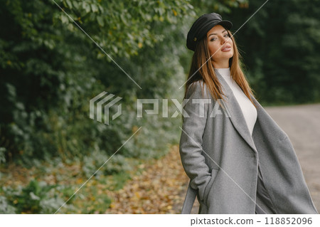 Girl walks. Woman in a gray coat. Brunette with a black cap. 118852096