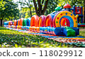 Row of inflatable toys sitting on top of lush green field. AI 118029912