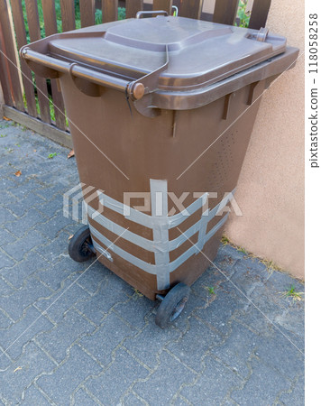 Damaged Brown Waste Bin with Amateur Repair 118058258