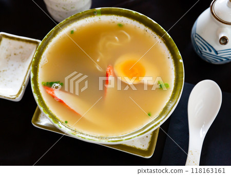 Traditional japanese noodle soup with mushroom, egg and greens served in bowl 118163161