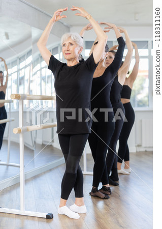 Graceful women of different ages practice at ballet stand in fifth position 118311160