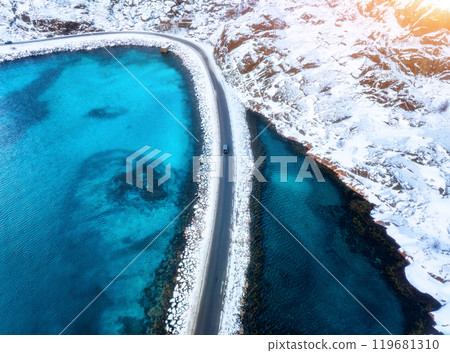 Aerial view of curved snowy road to the island and blue sea 119681310