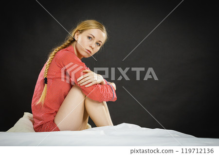 Sad depressed young woman in bed 119712136