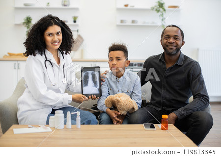 Doctor showing x-ray to father and sick child at home visit 119813345