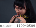 Image of the girl with yellow anaconda on shoulders and neck 119940509