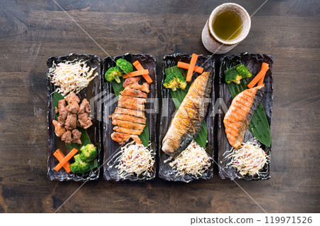 Grilled Salmon, Saba, Chicken, Pork and vegetable in black ceramic tray on wooden table 119971526