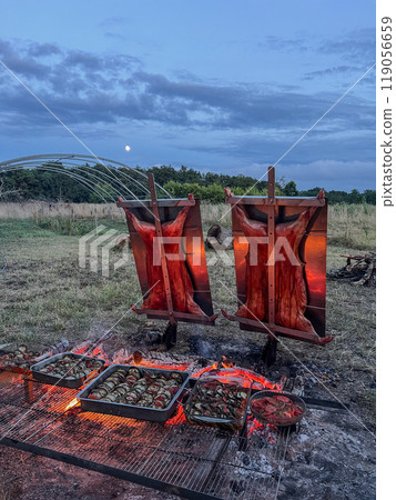 Traditional Argentinian asado, lamb and piglet slow-cooked over a wood fire and brushed with a spicy 119056659