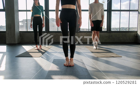 Group yoga. Indoor sport. Woman pilates coach training active people body physical exercise on mat in gym fitness class studio. 120529281