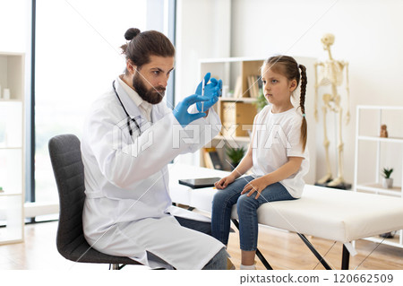 Doctor prepares vaccination for young girl in medical clinic 120662509