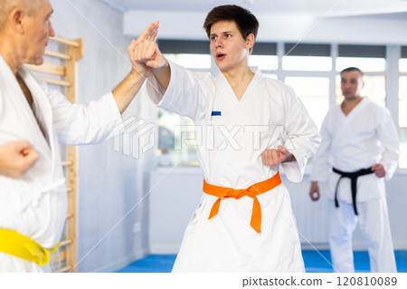 Elderly and young men training karate fight 120810089