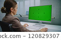 Professional female financial expert enters data using computer with green screen chroma key 120829307