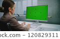 Professional female financial expert enters data using computer with green screen chroma key 120829311