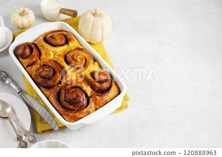 Cinnamon bun roll with pumpkin in baking dish. Homemade autumn Oven bakery desert for breakfast, copy space for racepie 120888963