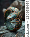 A detailed view of a snake ring resting on a rock surface 120956444