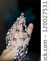 Woman holding silver beaded disco garland for christmas decoration. New Year 2025 120027531