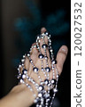 Woman holding silver beaded disco garland for christmas decoration. New Year 2025 120027532