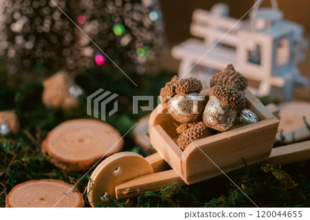 A warm winter decoration made with glitter acorns and wooden carts 120044655