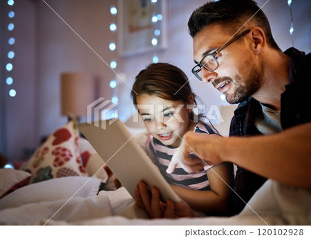 Which one shall we read tonight. Cropped shot of a father reading his young daughter a bedtime story on a tablet. 120102928