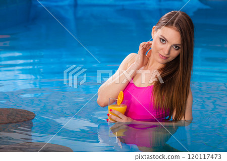 Girl relaxing at swimming pool with drink 120117473