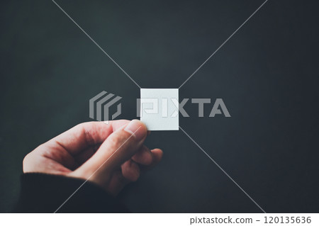 A person holding a small piece of paper 120135636