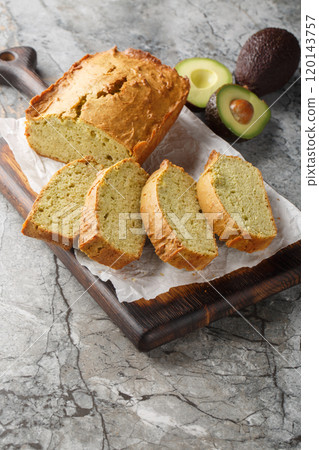 Homemade avocado bread sliced close up on wooden board. Vertical 120143757