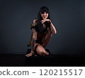 Photo of the brunette woman squatting with python 120215517