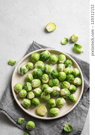 Fresh brussels sprouts in a plate on a light gray background with napkin. 120312152