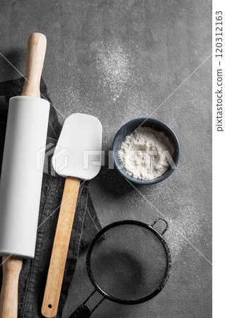 Flour, rolling pin, spatula and sifter on dark background. Set of ingredients for baking. 120312163